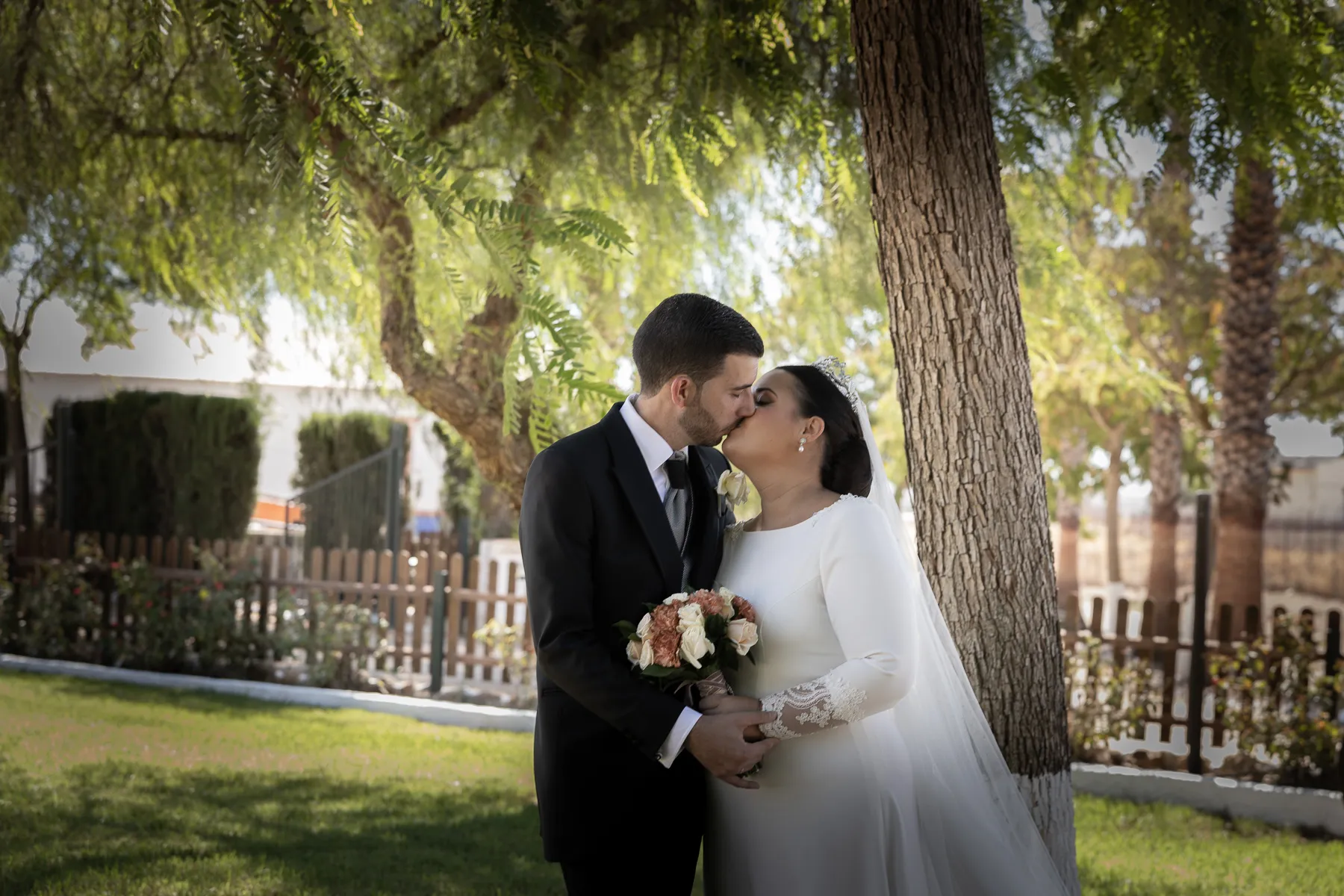 Marina y José besándose antes de entrar al banquete de su boda. 