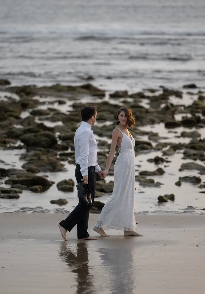 Estibaliz y Diego. Pareja de novios pasean de la mano en Playa Zahora