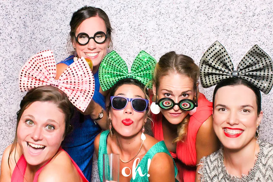Cinco chicas elegantes divertidas con lazos de colores brillantes y gafas de disfraces  