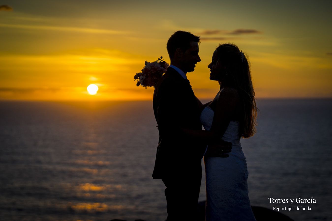 Silueta de los novios con la puesta de sol sobre el mar