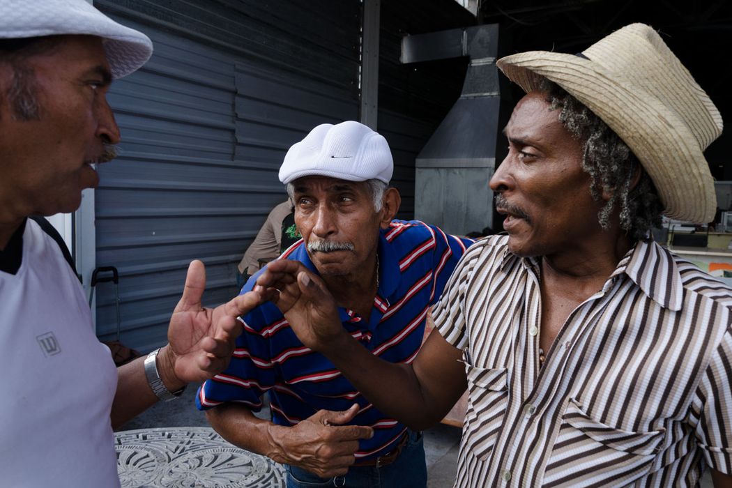 three cuban man speaking in group