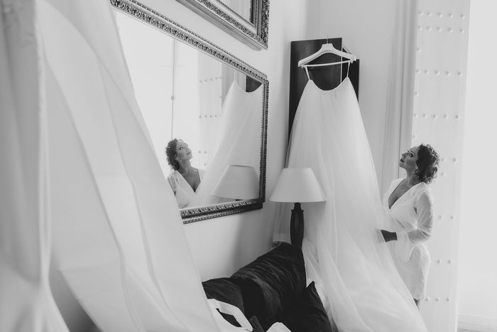 Imagen blanco y negro de una novia mirando su precisoso vestido