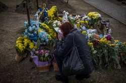 Una mujer besa la fotografía de su esposo, quien murió en los combates durante la guerra de Ucrania. Lviv, Ucrania. Marzo 2022.