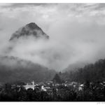 Pueblo con montaña entre nieblas