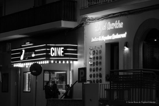 edificio antiguo de cine con luces brillantes en la oscuridad