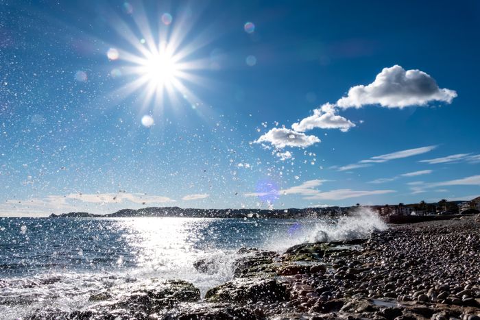 Sol de mediodía en la costa con un rompiente de olas