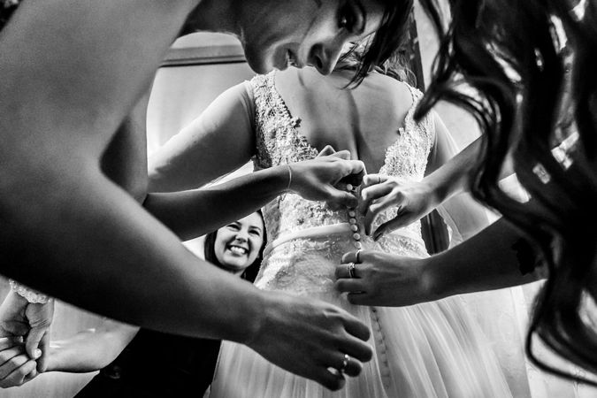 Las amigas ayudan a vestir a la novia