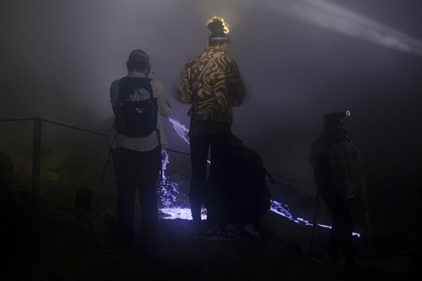 Tourist observe the blue lava in the caldera of the Ijen volcano