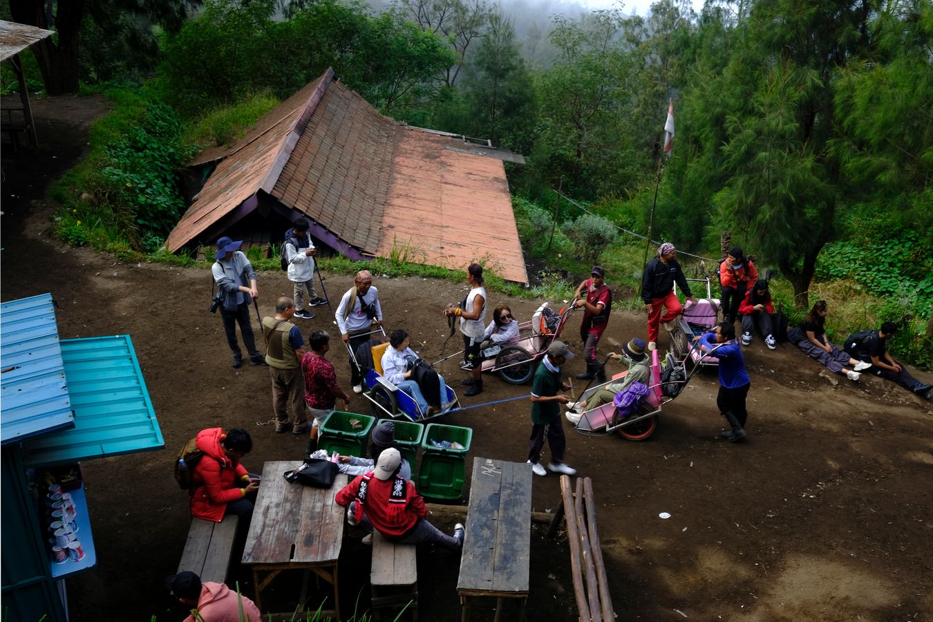 Wheelbarrow porters and tourists take a break on the way up to the top of Ijen volcano