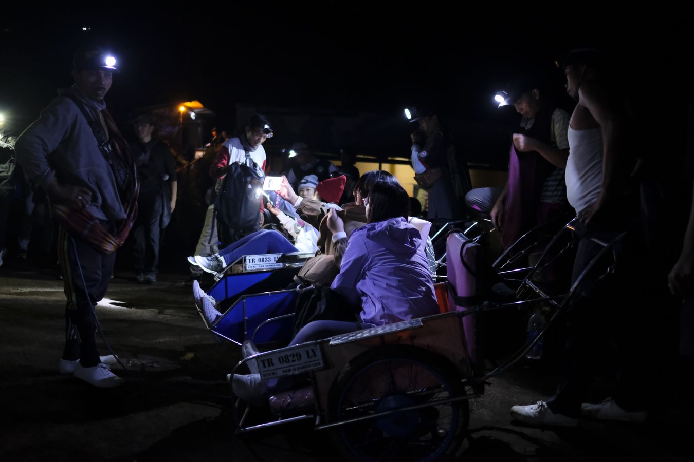 Wheelbarrow porters and tourists take a break on the way up to the top of Ijen volcano