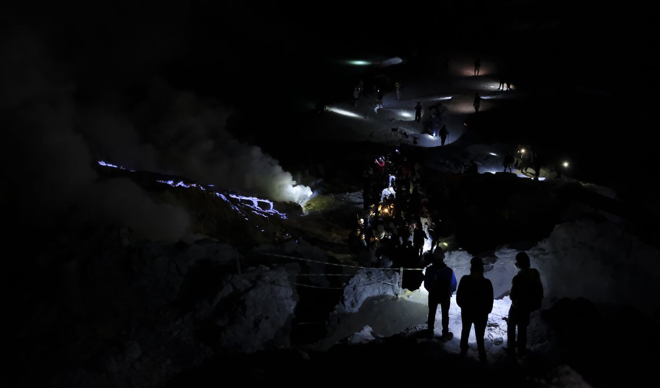 Tourists watch the blue lava in the crater of the Ijen volcano