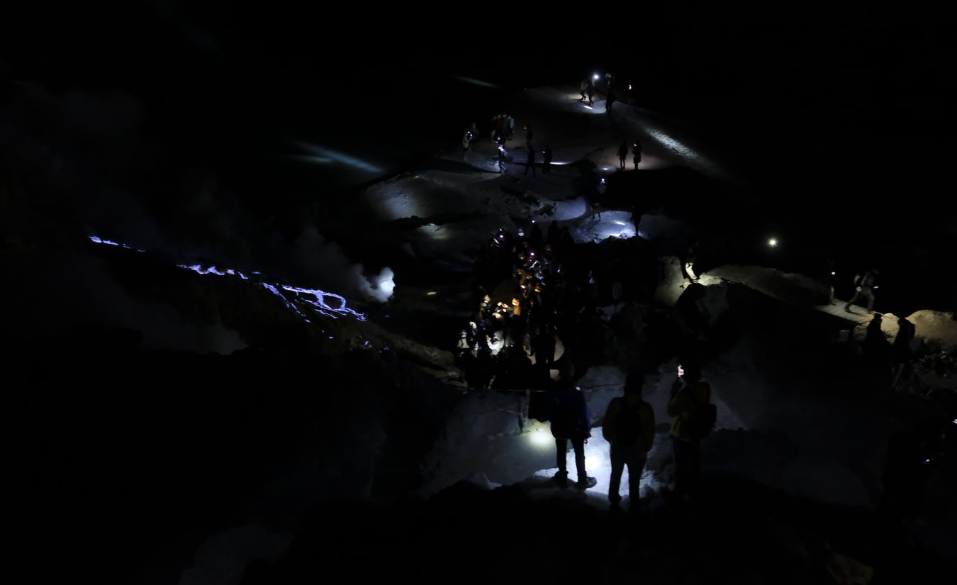 Tourists watch the blue lava in the crater of the Ijen volcano