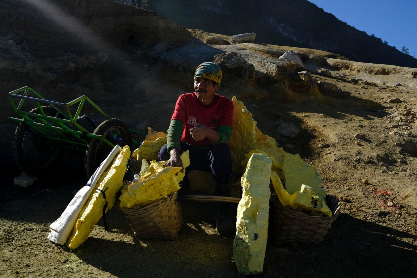 Miner rests for a moment surrounded by sulfur stones