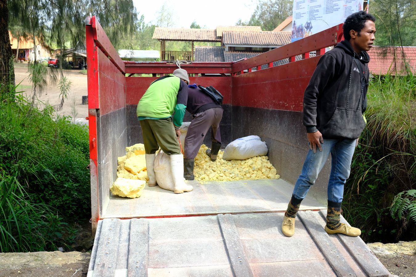 Miners deposit the already weighed sulfur in a truck for transport to the factory