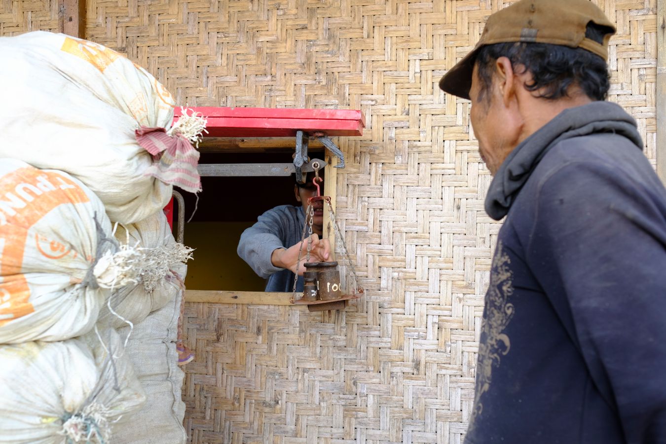 Miner looks at the scales that determine the weight of the sulfur collected last night