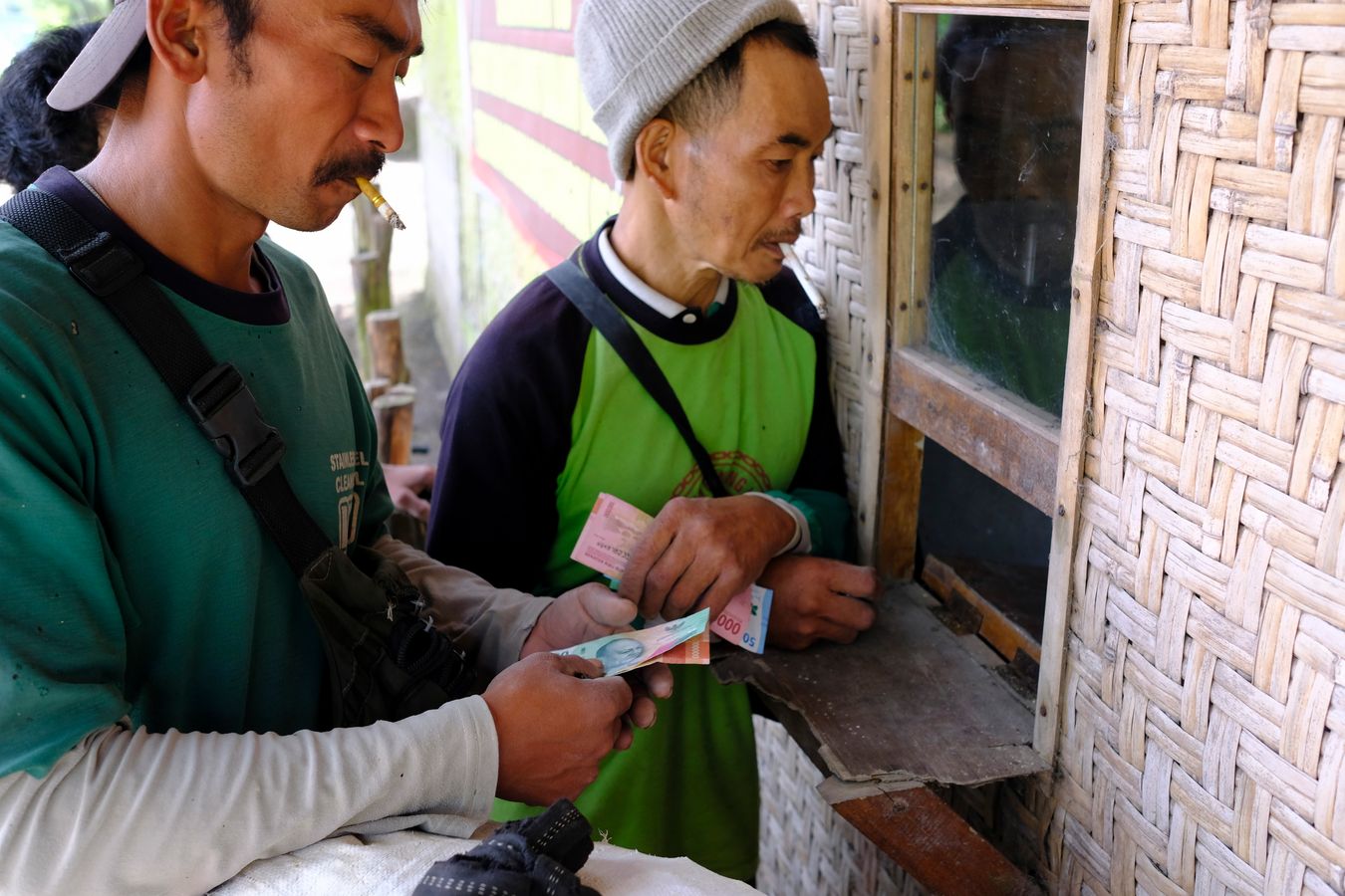 Miners receiving payment for the sulfur collected the night before