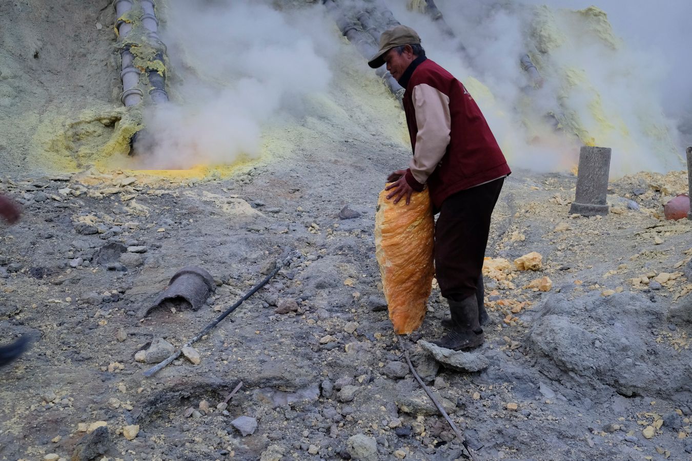 Miner has extracted a large stone of sulfur with the help of only an iron bar