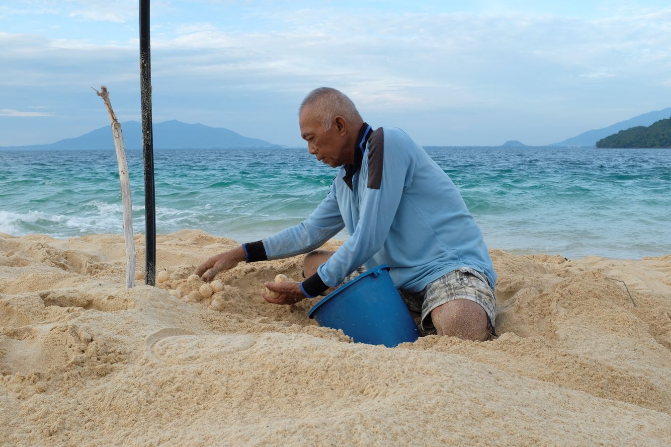 Mohamad, driver of the LPP boat collects sea turtle eggs at dawn.