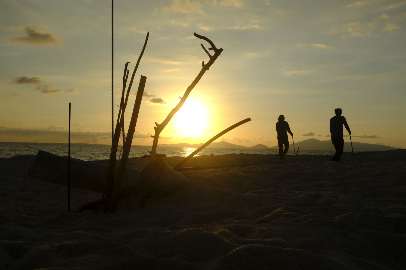 Rangers scour the beach at sunset.