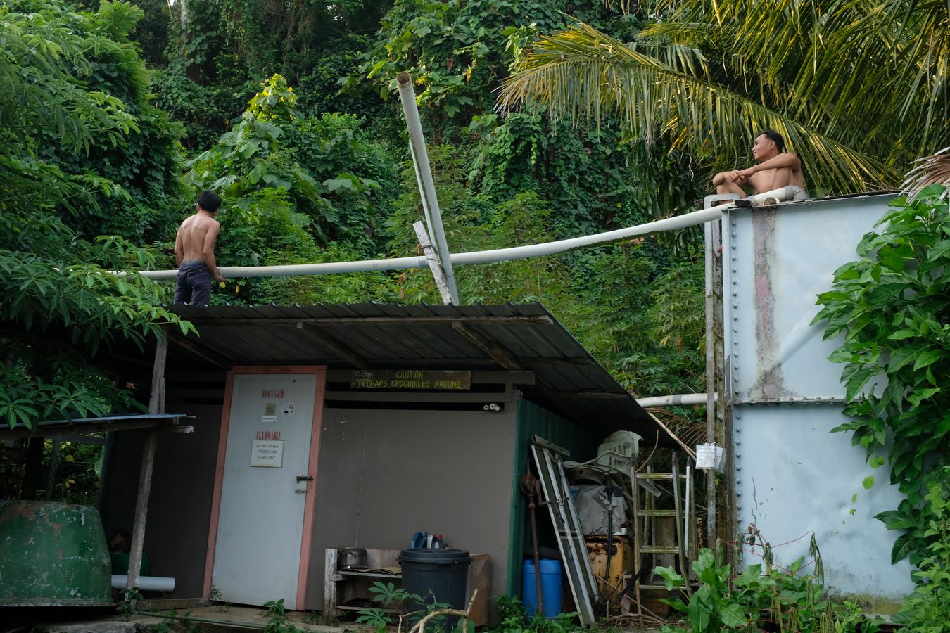 Two worker repair the simple pipes to collect rainwater. 