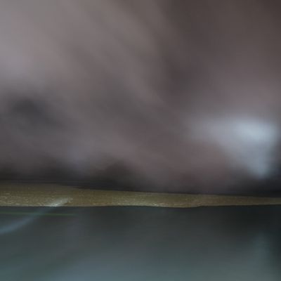 Acid particles in the lake, partially covered by smoke in the crater of the Ijen volcano at night