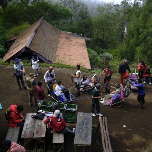 Wheelbarrow porters and tourists take a break on the way up to the top of Ijen volcano