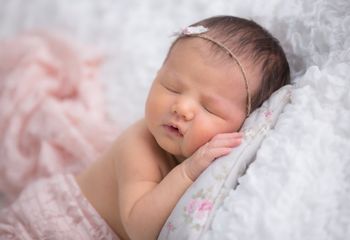 niña recien nacida dormida sobre almohada