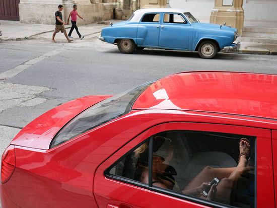 cuban girl inside a car connected to wifi area