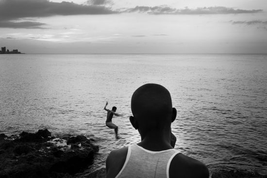 jumping to caribbean sea in Havana, Cuba. Photo essays about travels to Cuba