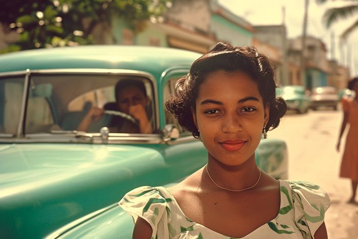 portrait of a brunette Cuban woman in Havana from the 50s vintage photography, behind her there is a green American car, AI photography