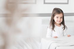 Niña en la cama con regalos navidad