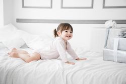 Niña en la cama con regalos navidad