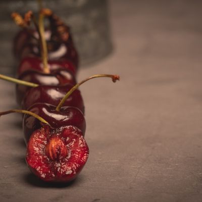 fila de cerezas sobre fondo oscuro cereza mordida