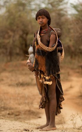 Mujer de la tribu Hamer con su hijo. vestida con pieles. Valle del Omo. Etiopia