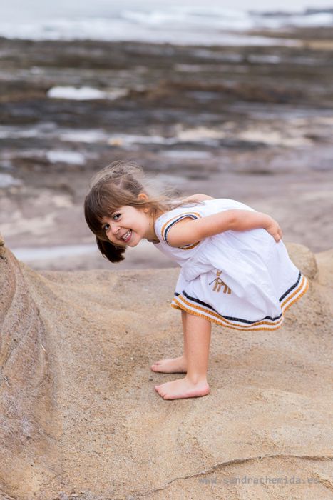 niña pequeña jugando en la playa