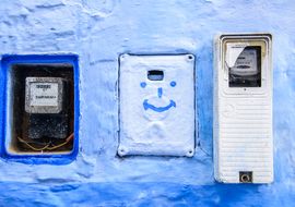 Contadores de la luz y sonrisa azul. Energía eléctrica y actitud positiva. Marruecos