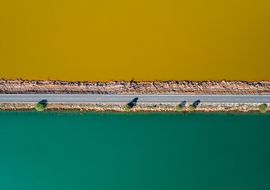 A road divide the fresh water from water contaminated by mining waste. Rio Tinto. Huelva. Spain